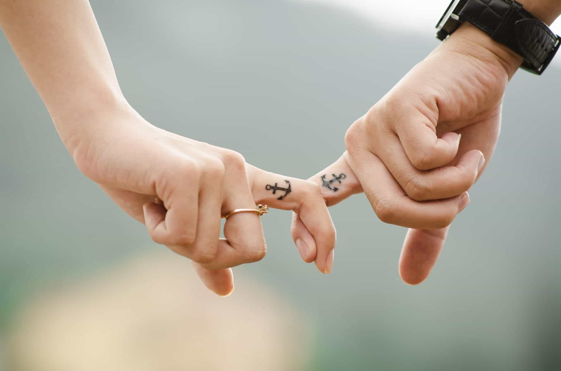 fingers holding hands with tattoos pexels-photo-38870