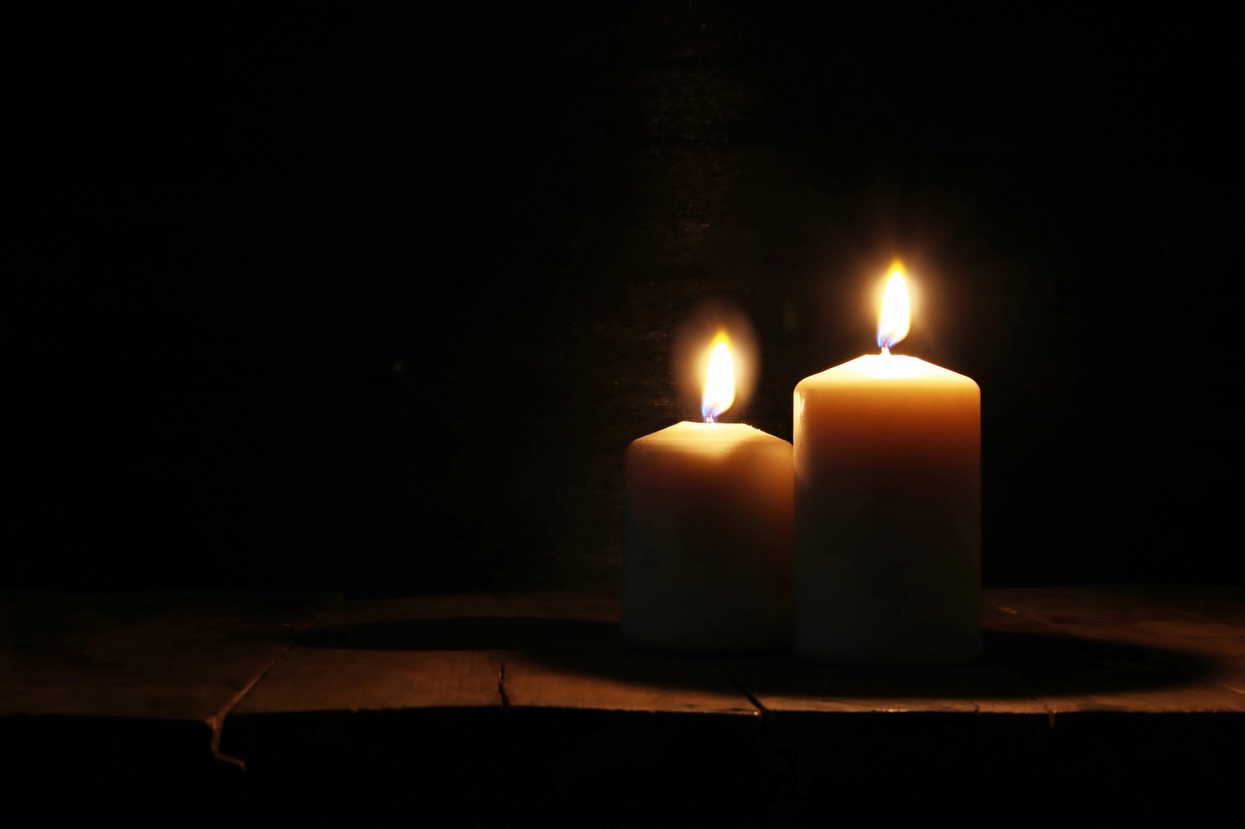 Burning candles over old wooden table with bokeh lights